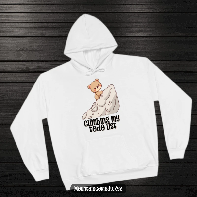 Funny hoodie featuring a sturdy bear cub carefully ascending a steep, rocky mountain, symbolizing strength and perseverance.