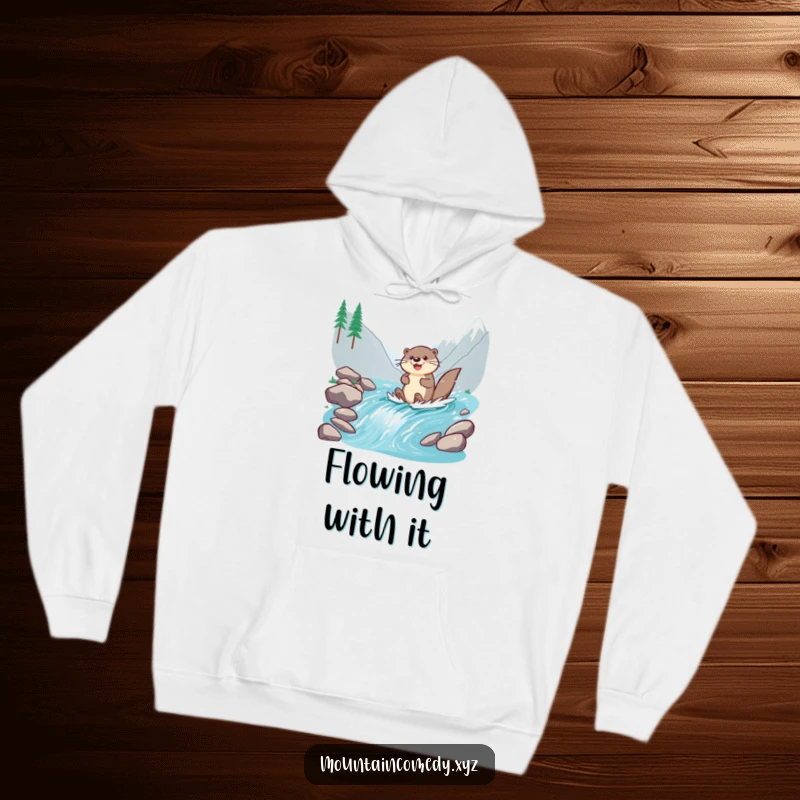 Funny otter character paddling enthusiastically down a mountain stream, depicted on a warm and cheerful hoodie for water lovers.