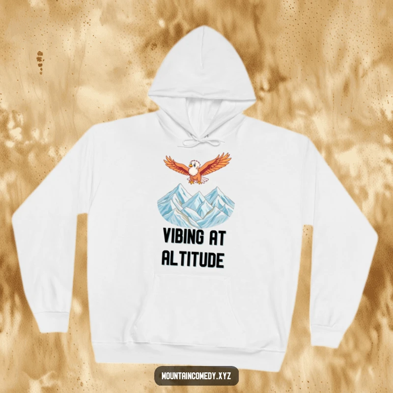 Funny hoodie featuring an energetic eagle character soaring high above a majestic mountain range, ideal for cozy adventure vibes.
