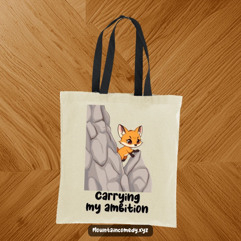 Funny fox cub character scaling a steep, rocky cliff with determination, featured on a stylish and humorous tote bag.