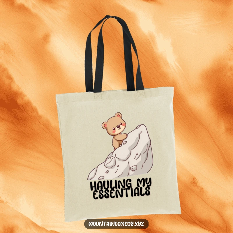 Funny tote bag with a sturdy bear cub character carefully climbing a steep, rocky mountain, great for outdoor excursions.
